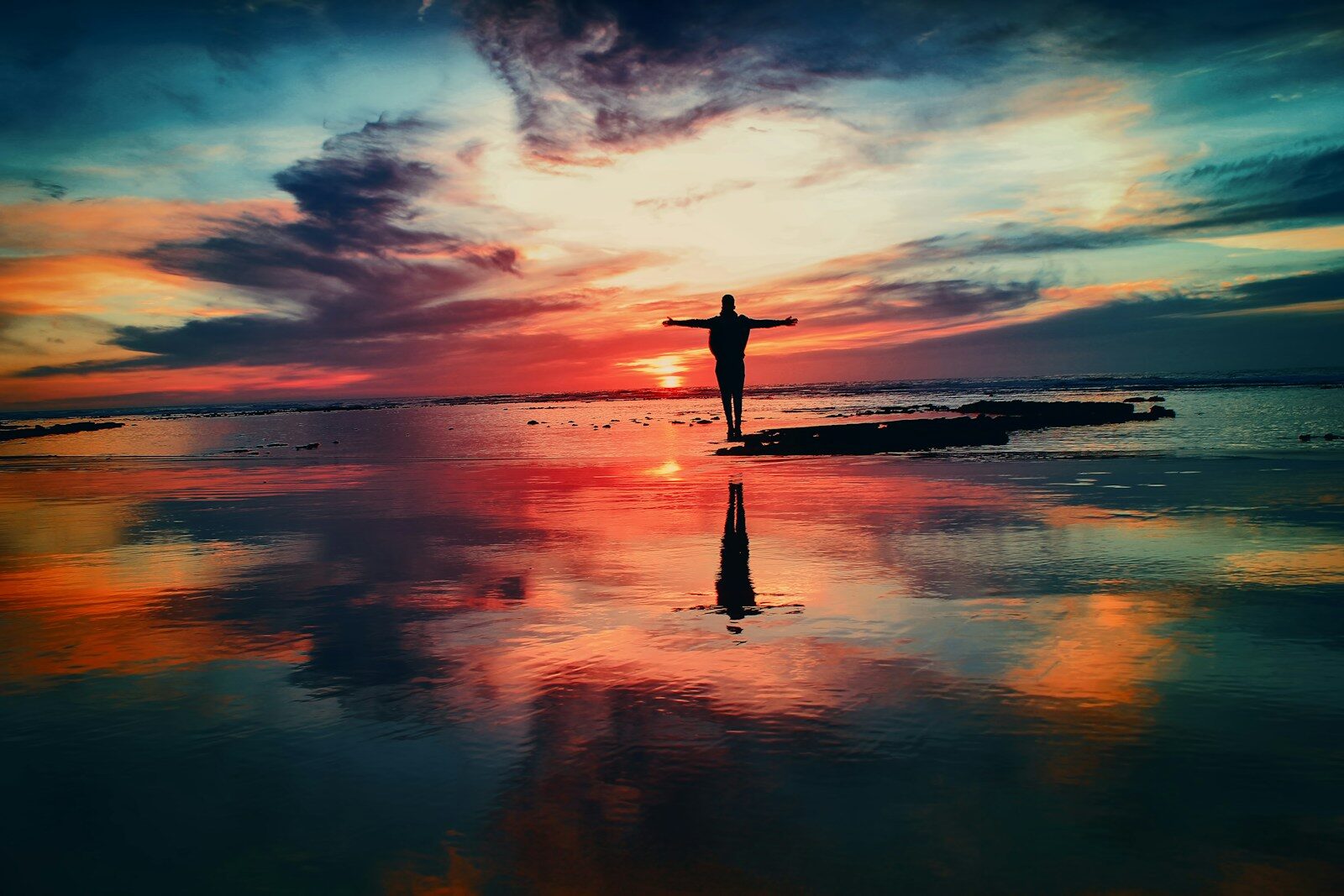 DMP silhouette of person standing on rock surrounded by body of water